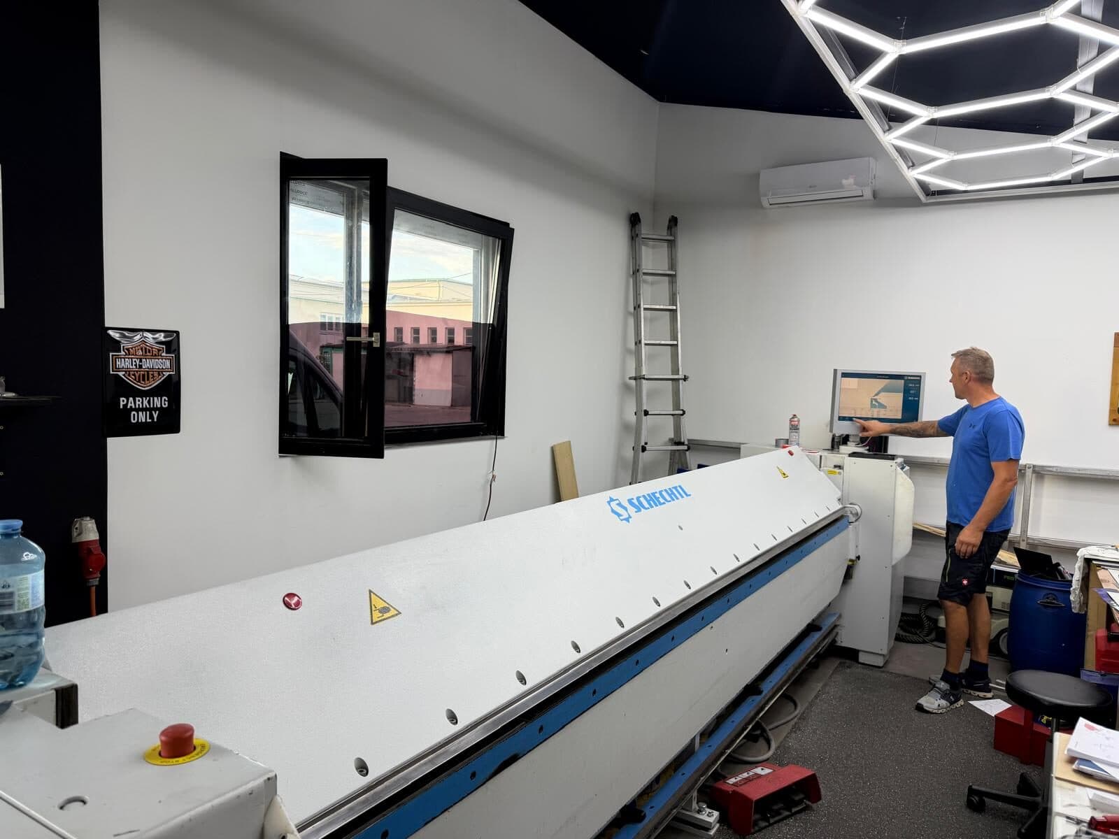 Der Inhaber an der Steuerung der CNC-Schwenkbiegemaschine in der Werkstatt.